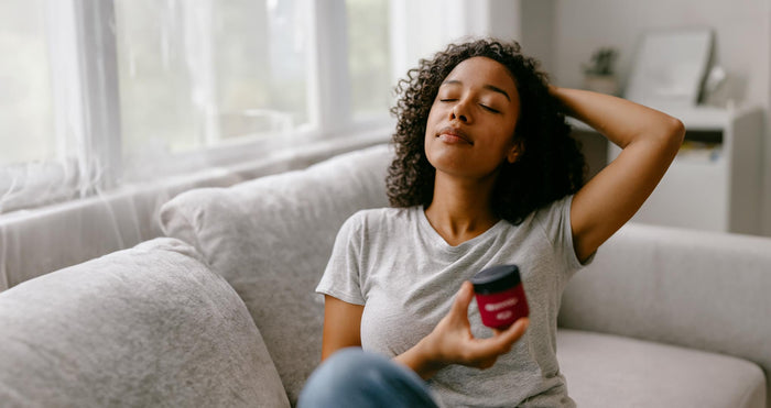 Person relaxing at home holding MONTKUSH True Vibe Gummies for stress relief before the weekend